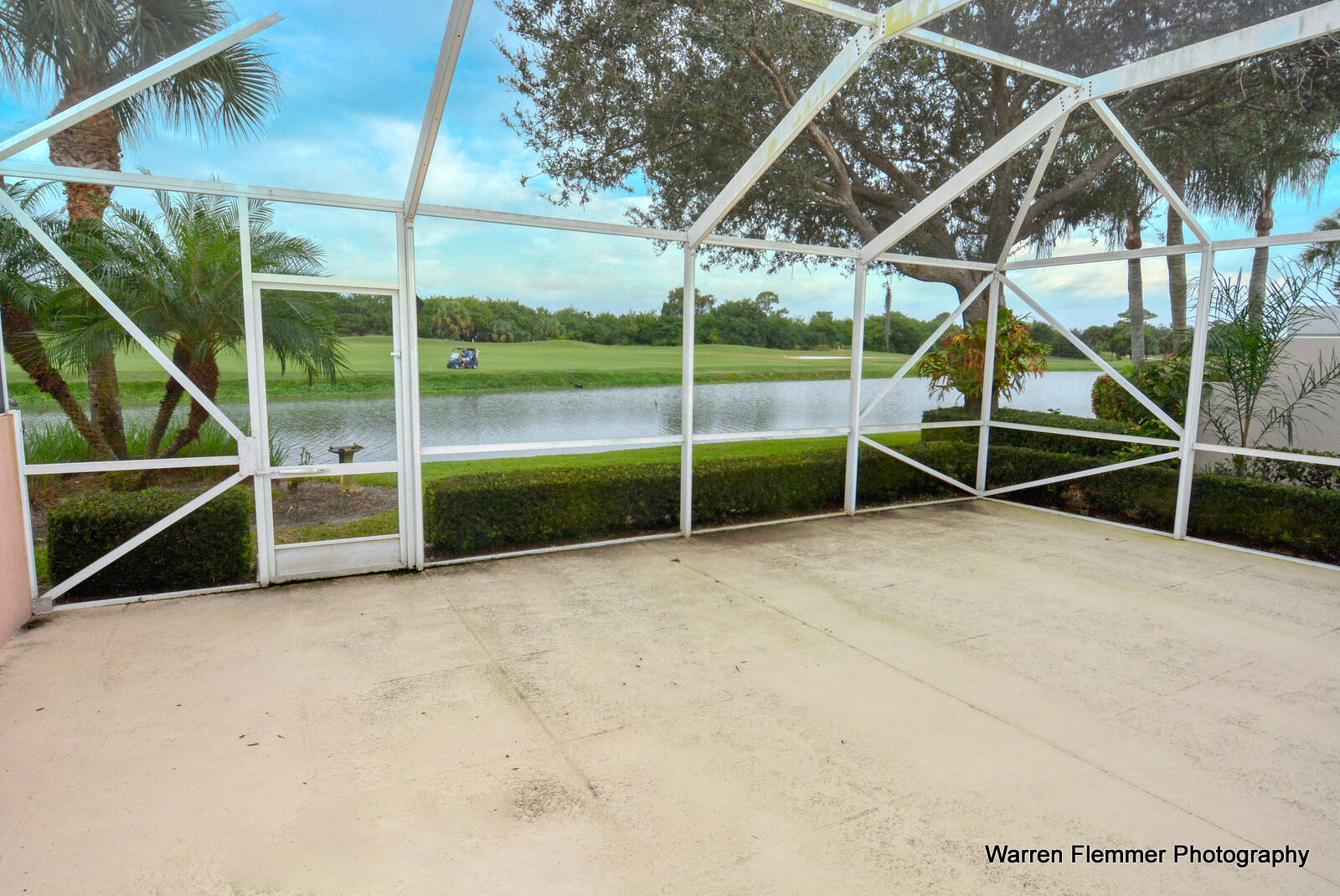 1044 Southwest Balmoral Trace Stuart, FL 34997 - Photo 23 of 34 a view of an empty room with wooden floor and a small garden