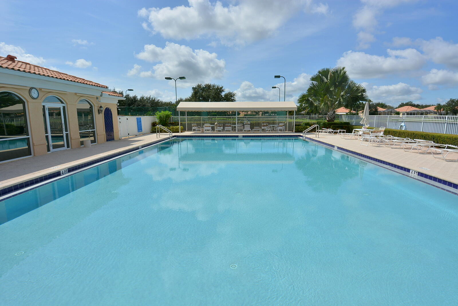 1044 Southwest Balmoral Trace Stuart, FL 34997 - Photo 29 of 34 a view of a swimming pool with an outdoor seating and a garden