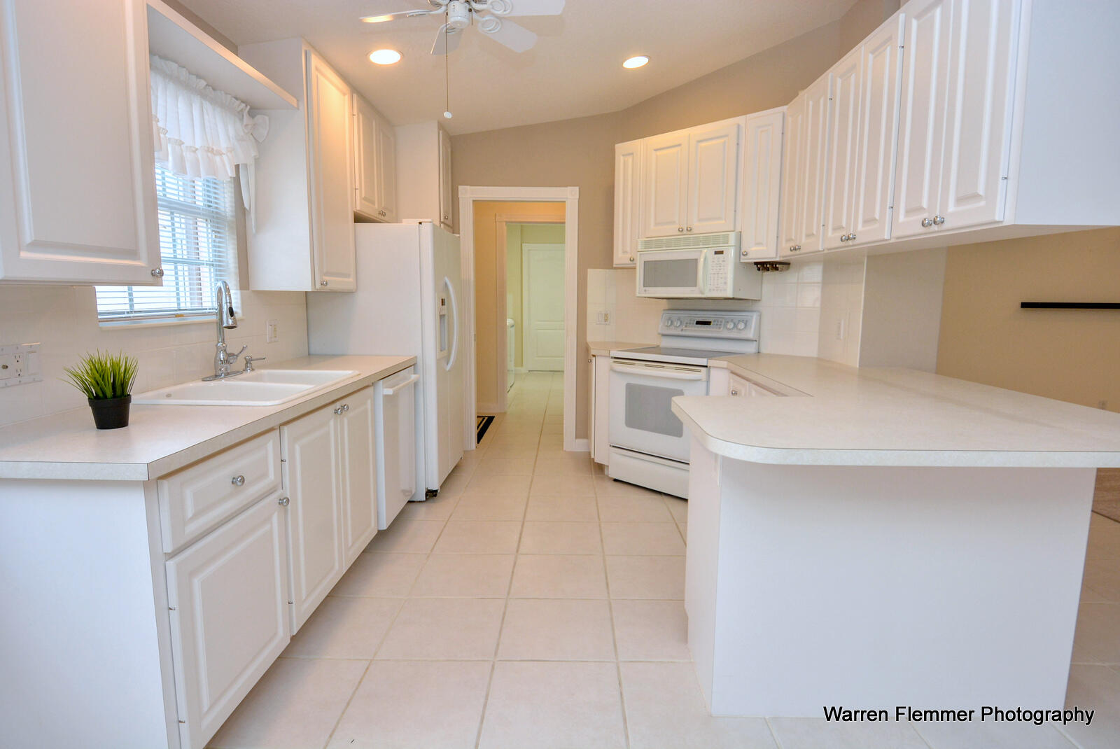 1044 Southwest Balmoral Trace Stuart, FL 34997 - Photo 8 of 34 a kitchen with stainless steel appliances granite countertop a sink dishwasher stove and white cabinets with wooden floor