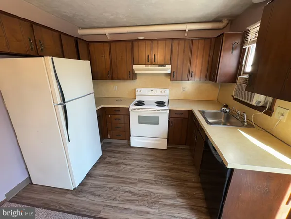 a kitchen with a refrigerator sink stove and cabinets
