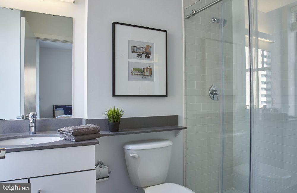 1616 Walnut Street, Unit 3B2110 Philadelphia, PA 19103 - Photo 28 of 28 a bathroom with a toilet a sink and mirror