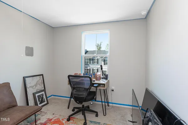 a view of a workspace with furniture and a window