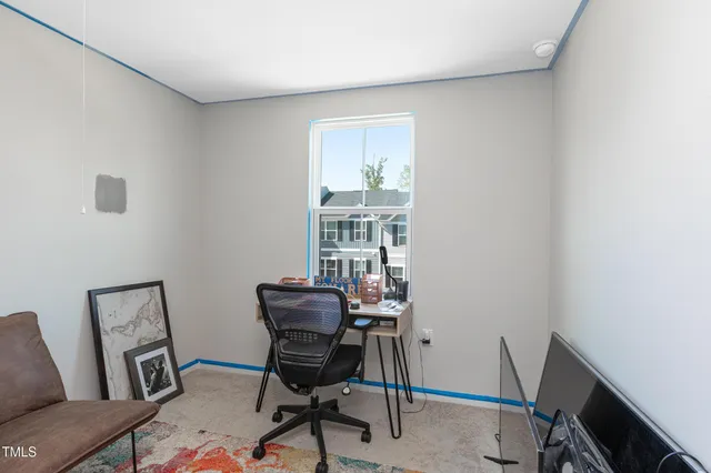 a view of a workspace with furniture and a window