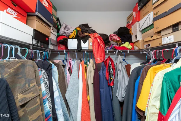 a view of walk in closet with clothes and shoes