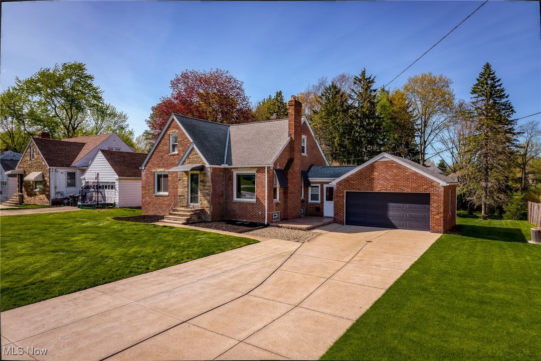6315 Brookside Road Independence, OH 44131 - Photo 40 of 41 View of front of property with brick siding, an attached garage, a front yard, and concrete driveway