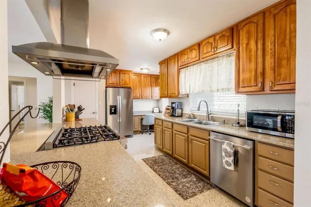 a kitchen with stainless steel appliances granite countertop a sink stove and refrigerator