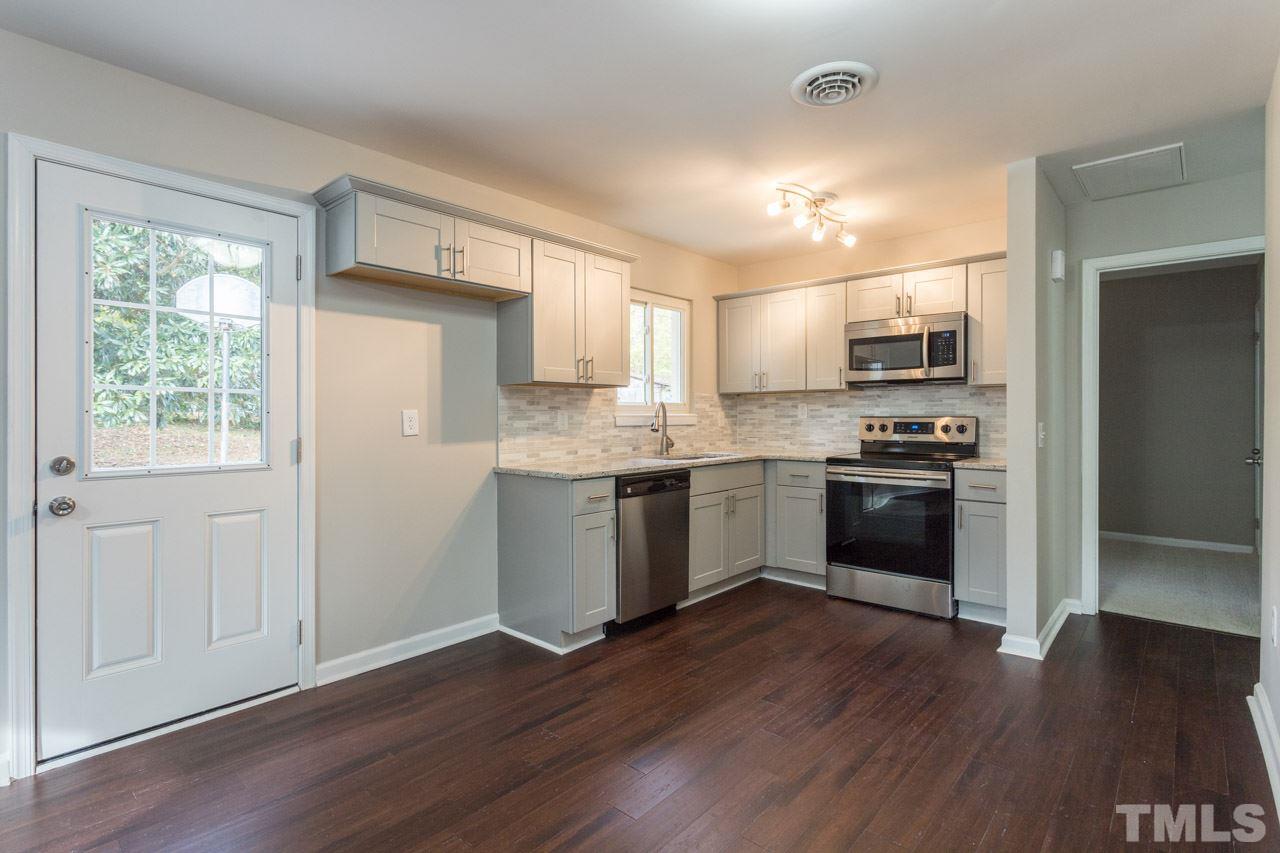 2708 Sanderford Road Raleigh, NC 27610 - Photo 7 of 21 a kitchen with kitchen island granite countertop a sink cabinets and stainless steel appliances