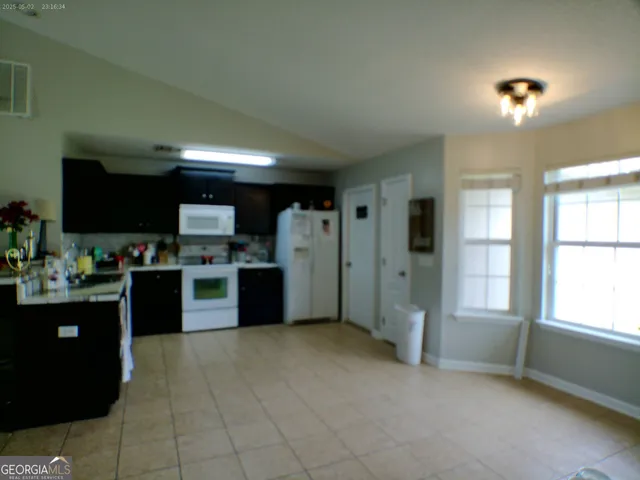 a kitchen with stainless steel appliances kitchen island granite countertop a refrigerator and a stove top oven