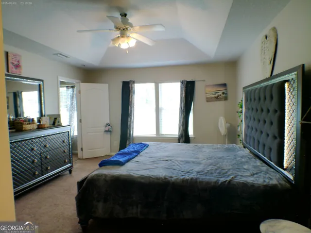 a bedroom with a large bed and a chandelier