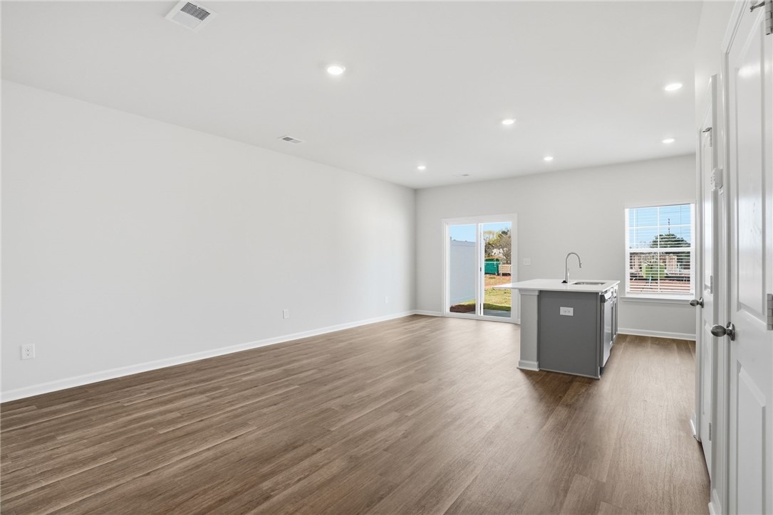 319 Lilac Loop Greenwood, SC 29649 - Photo 8 of 25 This bright, open-concept living space features stylish flooring and convenient backyard access.