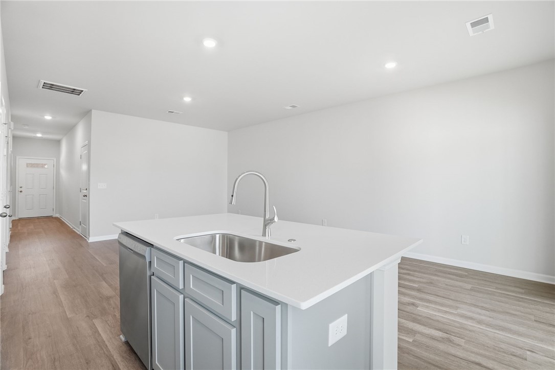319 Lilac Loop Greenwood, SC 29649 - Photo 10 of 25 This modern kitchen features a spacious island, sleek countertops, and an open-concept design.