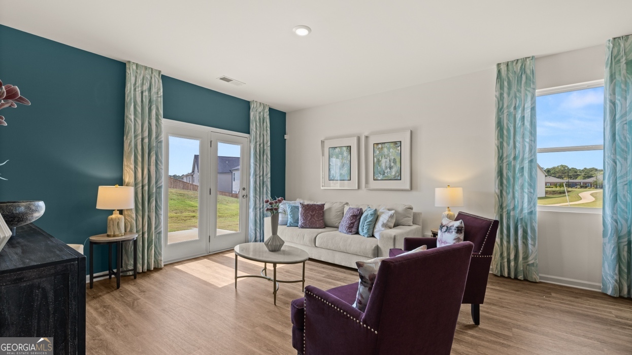 11933 Aukerman Way Hampton, GA 30228 - Photo 15 of 41 a living room with furniture and a floor to ceiling window