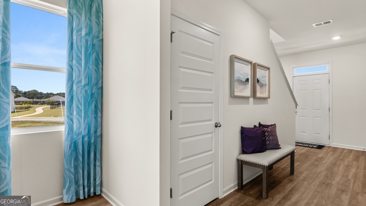 11933 Aukerman Way Hampton, GA 30228 - Photo 22 of 41 a view of a hallway with wooden floor and a cabinet