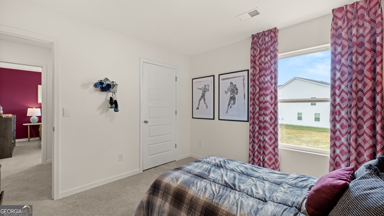 11933 Aukerman Way Hampton, GA 30228 - Photo 35 of 41 a bedroom with a bed and a chandelier