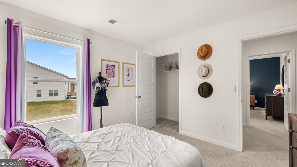 11933 Aukerman Way Hampton, GA 30228 - Photo 38 of 41 a bedroom with a bed and a large mirror