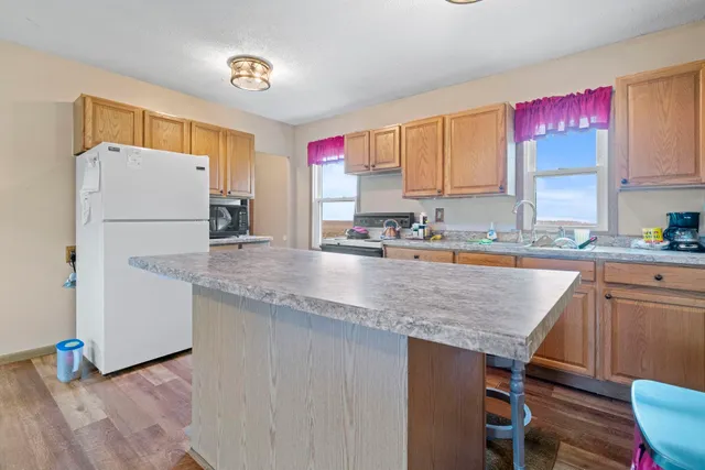 a kitchen with granite countertop a sink a counter top space and cabinets