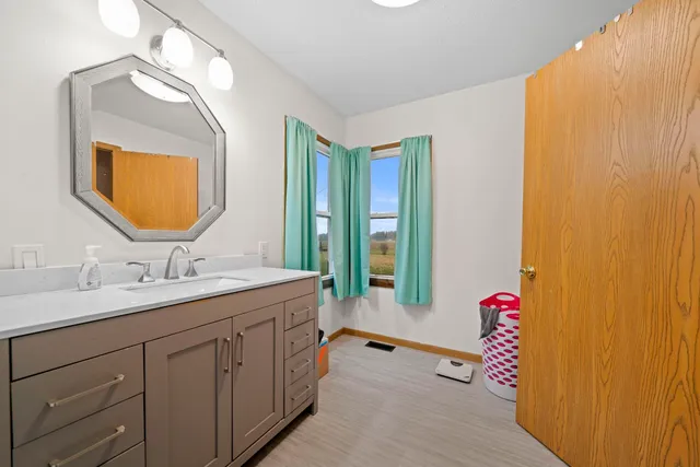 a bathroom with a granite countertop sink and a mirror