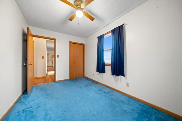 an empty room with closet and chandelier fan
