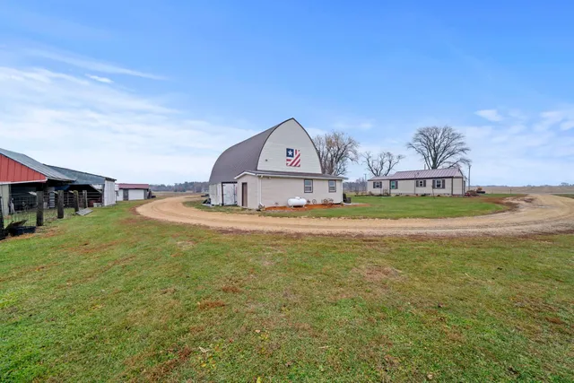 a view of a house with a big yard and large trees
