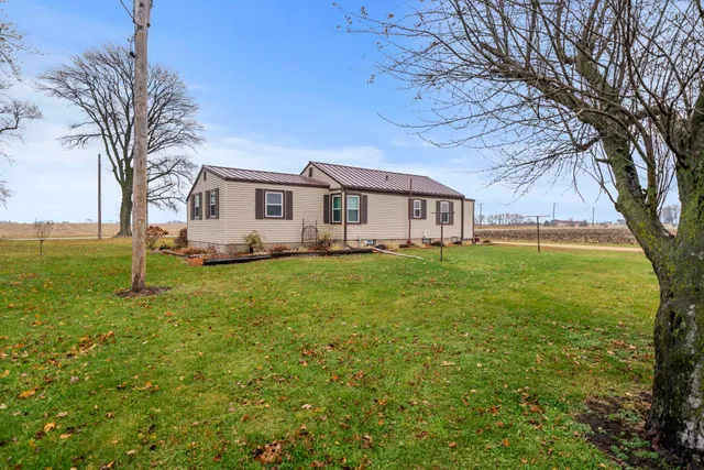 a white house that has a tree in front of it