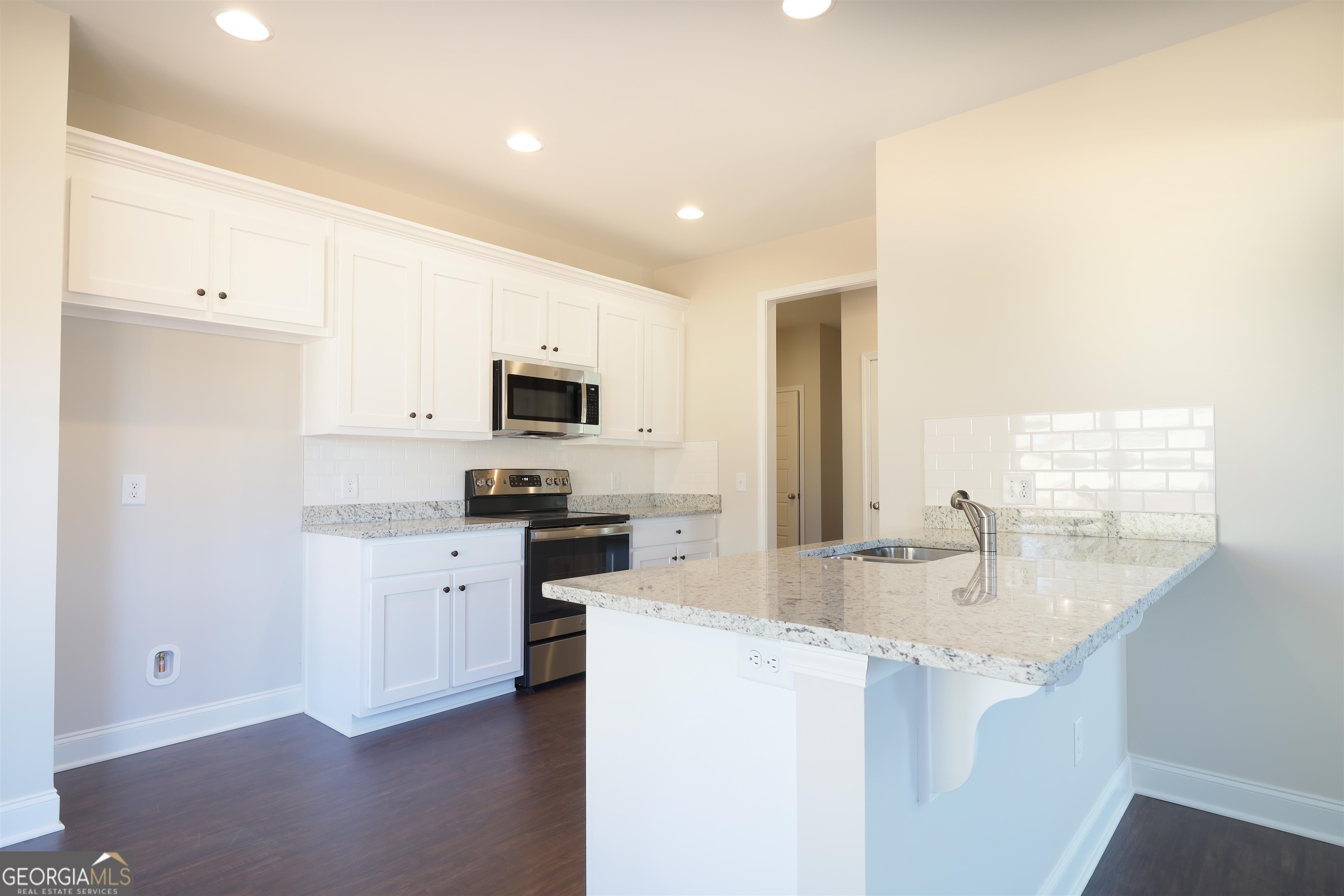230 Delightful Way, Unit 23 Winder, GA 30680 - Photo 10 of 26 a kitchen with stainless steel appliances granite countertop a sink stove and refrigerator