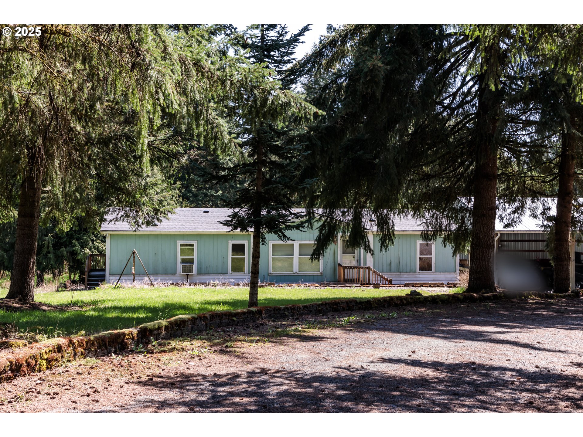 a view of a white house next to a yard with big trees