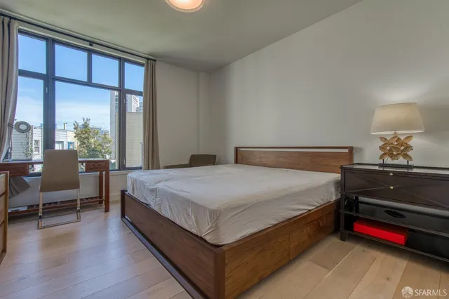 a spacious bedroom with a bed and a dresser