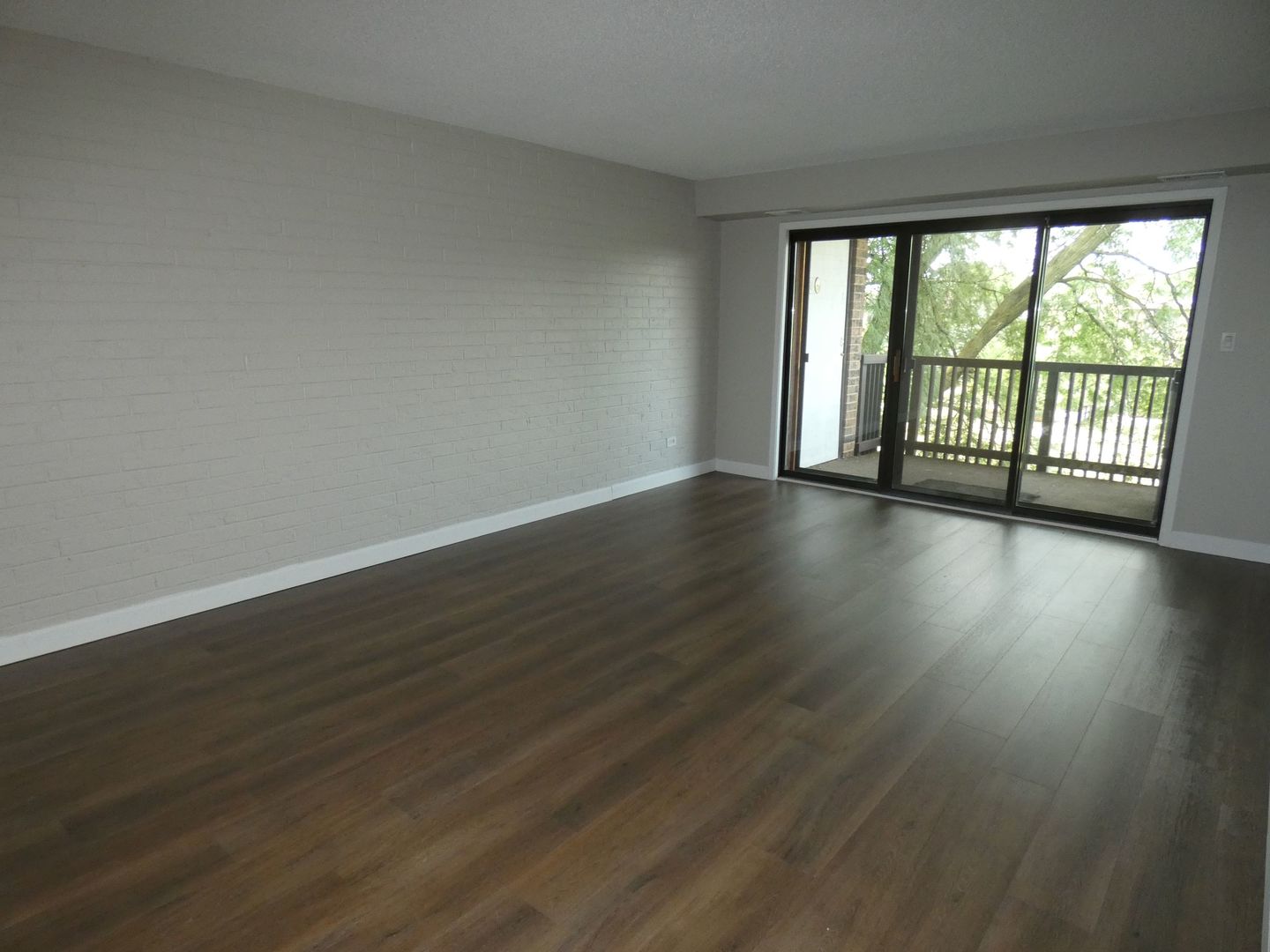 1501 Woodbridge Road, Unit 3C Joliet, IL 60436 - Photo 8 of 24 a view of an empty room with wooden floor and a window