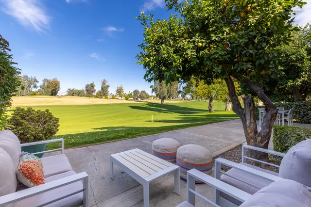 a view of a patio with lawn chairs under an umbrella