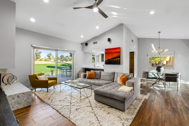 a living room with fireplace furniture and a large window