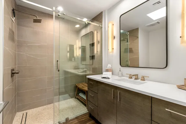 a bathroom with a double vanity sink mirror and shower