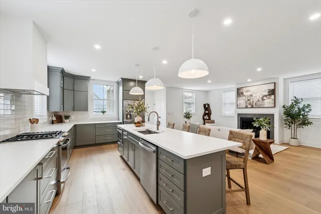 a large kitchen with kitchen island a large counter top space a sink stainless steel appliances and cabinets