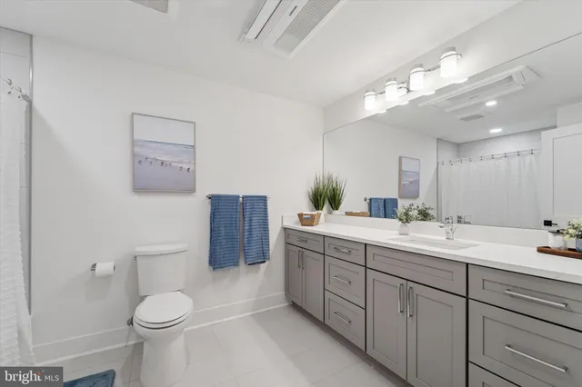 a bathroom with a double vanity sink toilet and a mirror