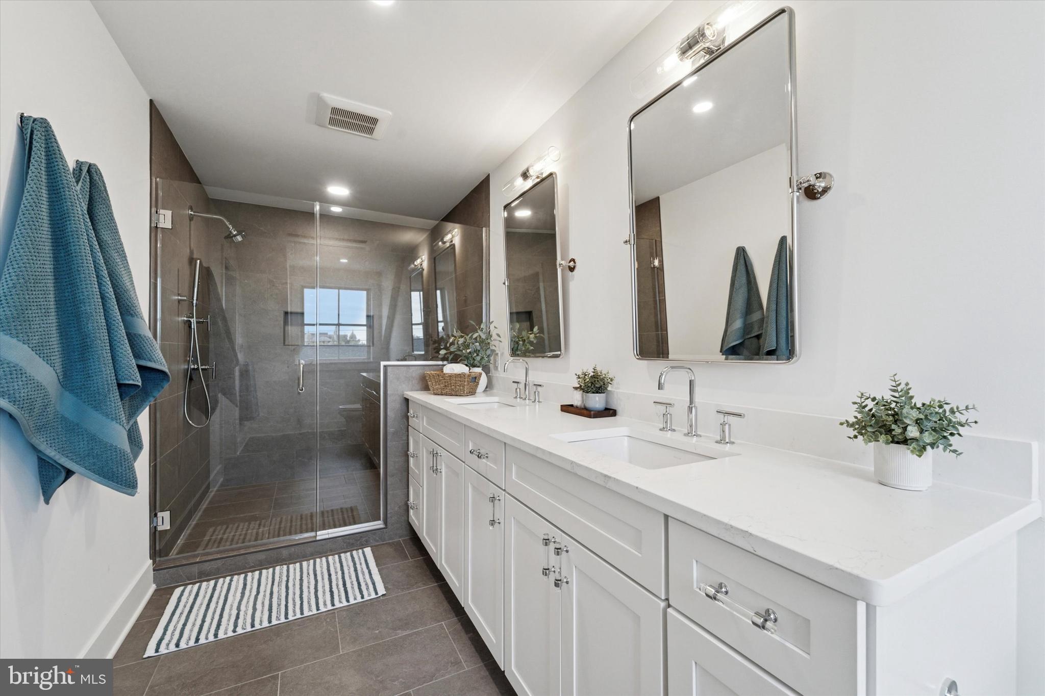 25 North Ridge Avenue, Unit A Ambler, PA 19002 - Photo 24 of 26 a bathroom with double vanity sink a shower and a mirror