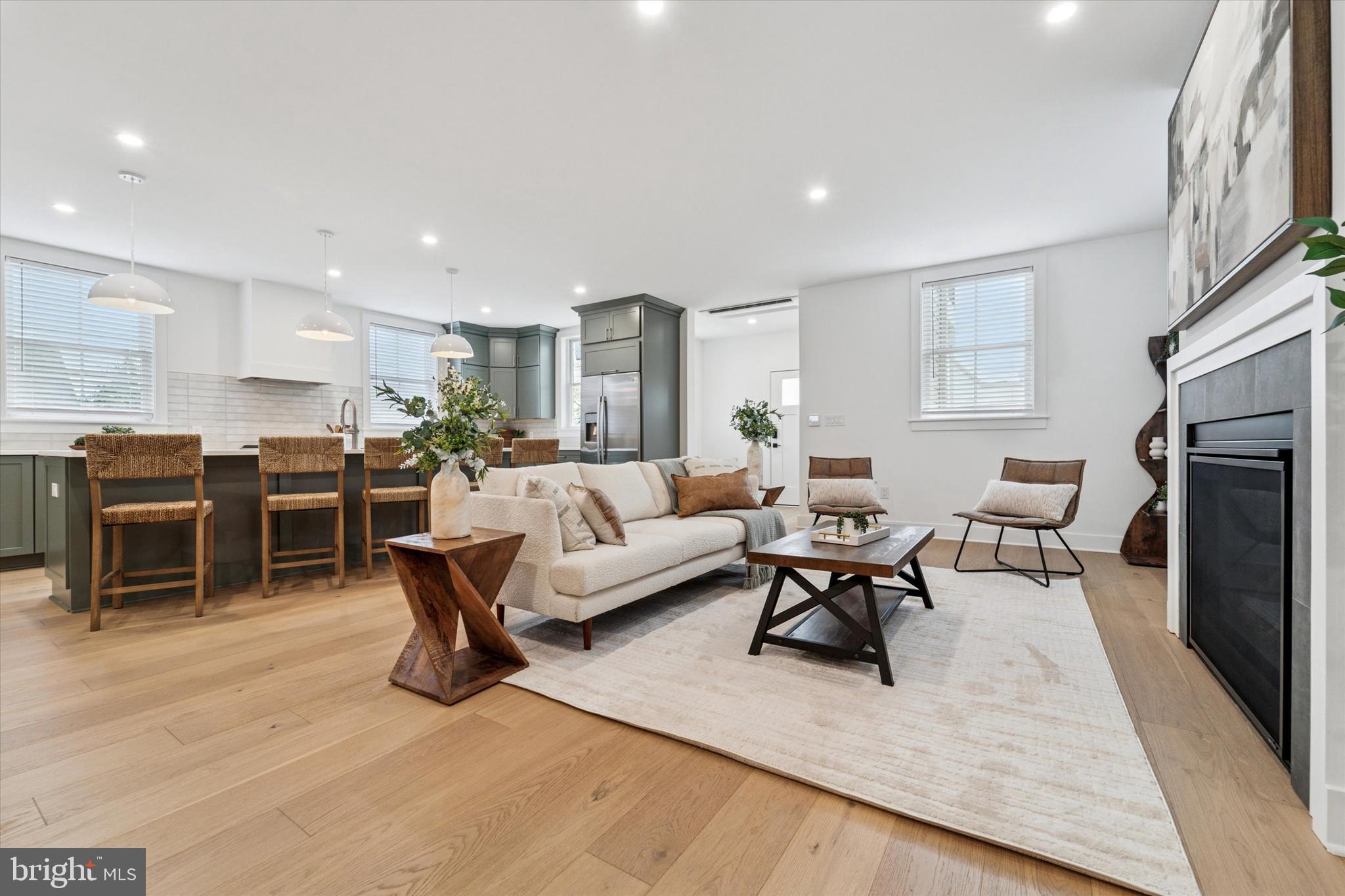 25 North Ridge Avenue, Unit A Ambler, PA 19002 - Photo 5 of 26 a living room with furniture a large window and a fireplace
