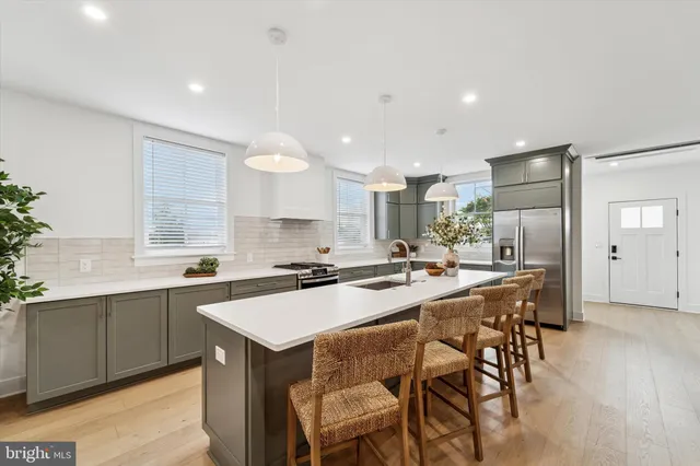 a kitchen with a sink a stove a refrigerator and chairs