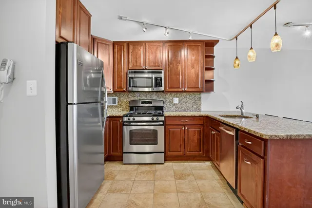 a kitchen with granite countertop stainless steel appliances and wooden cabinets