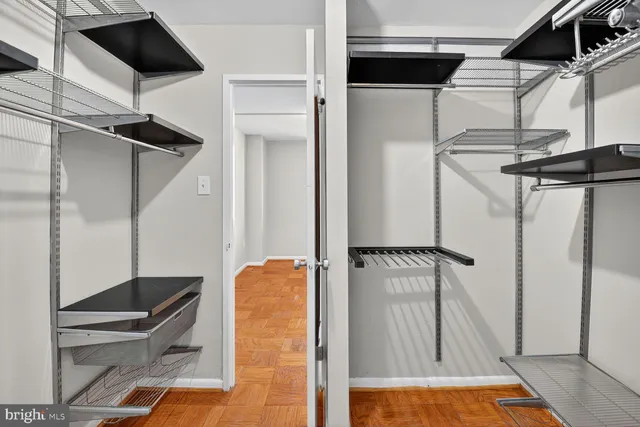 a view of walk in closet with clothes and shoes