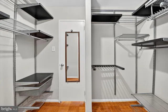 a view of walk in closet with clothes and shoes