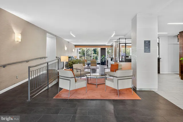a living room with furniture a rug and white walls