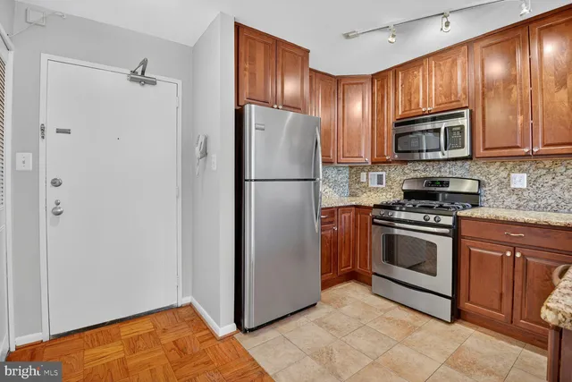 a kitchen with granite countertop stainless steel appliances and wooden cabinets