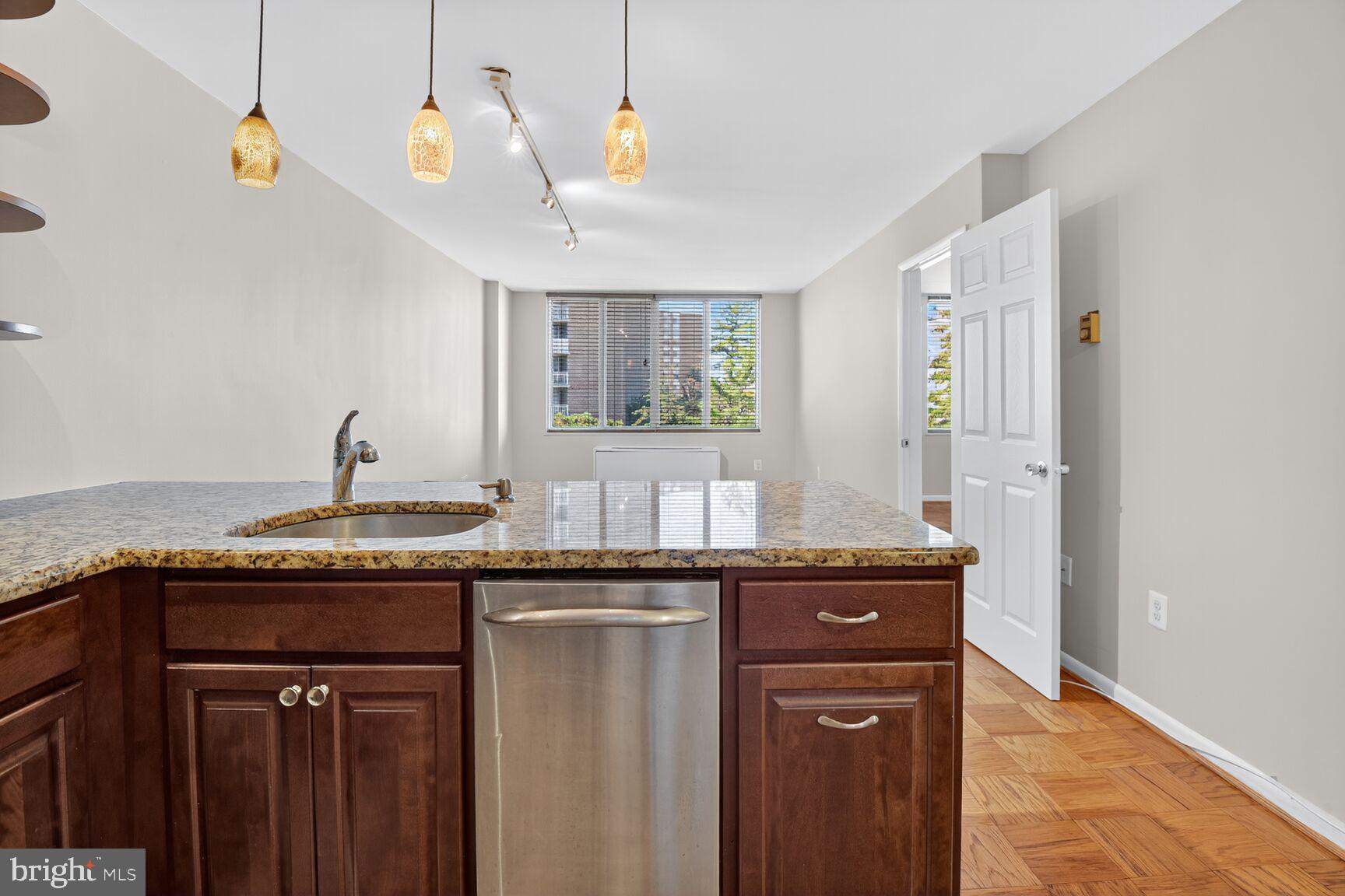 2939 Van Ness Street Northwest, Unit 941 Washington, DC 20008 - Photo 6 of 42 a kitchen with granite countertop a sink and a window