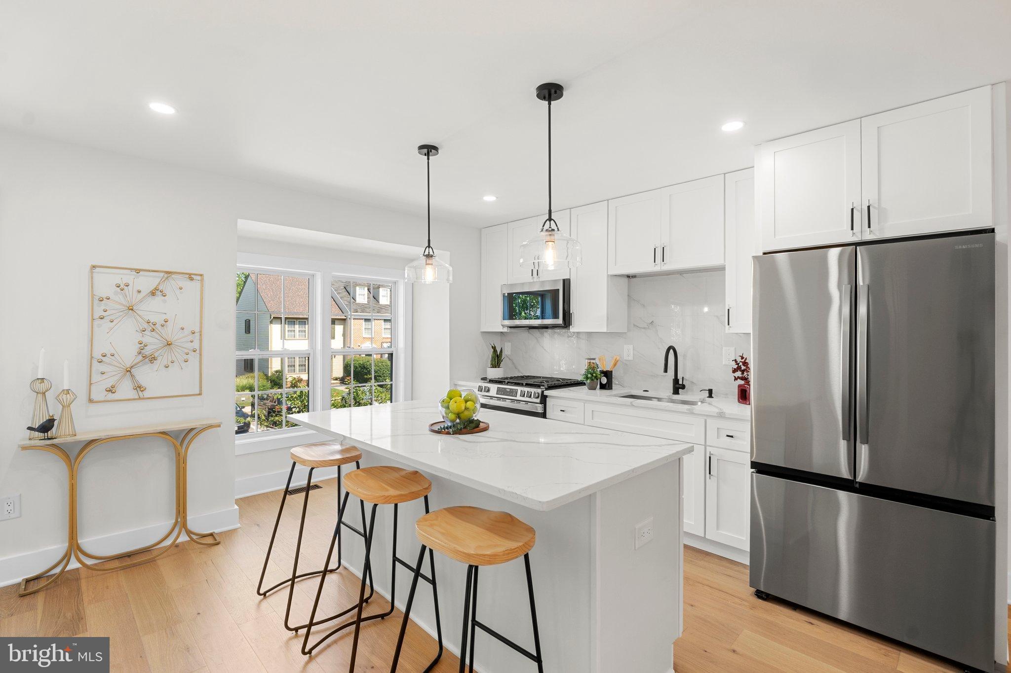 6213 Manchester Way Elkridge, MD 21075 - Photo 12 of 31 a kitchen with stainless steel appliances a refrigerator a stove a sink a dining table and chairs