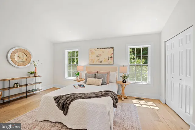 a bedroom with a bed a window and a chandelier