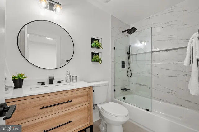 a bathroom with a sink mirror toilet and bathtub