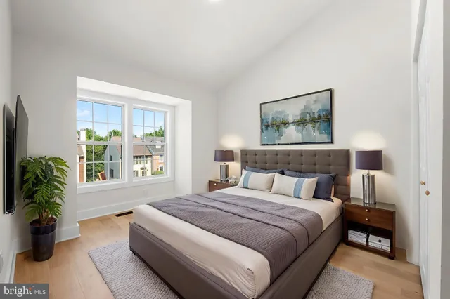 a bedroom with a large bed and a potted plant