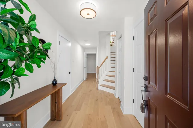 a view of a hallway with wooden floor and stairs