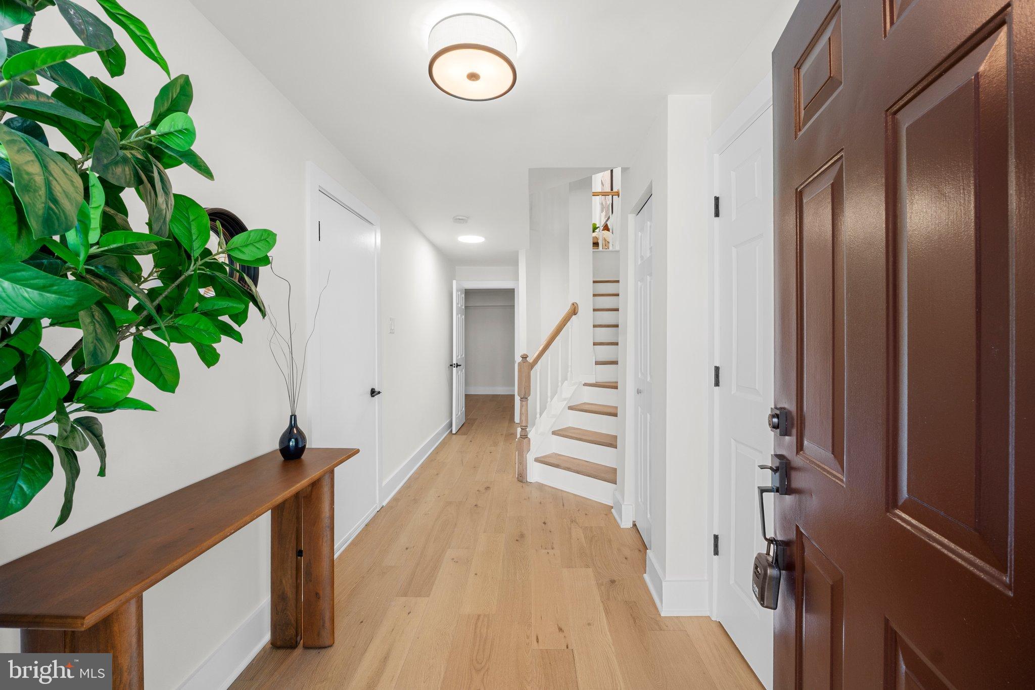 6213 Manchester Way Elkridge, MD 21075 - Photo 3 of 31 a view of a hallway with wooden floor and stairs