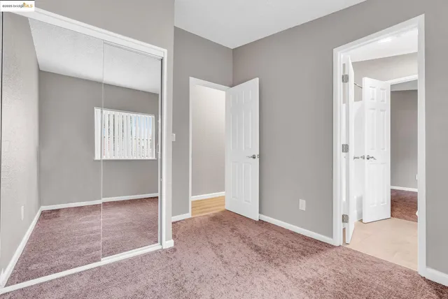 an empty room with windows and closet