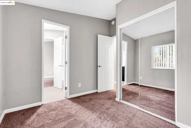 an empty room with windows and closet